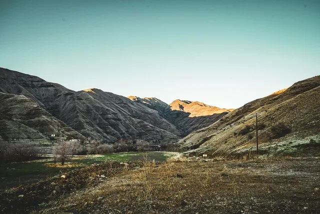 A rugged mountain valley in Hells Canyon, Idaho, with winding trails and golden hills.