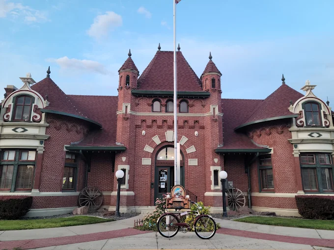 Nampa Train Depot Museum – Historic Landmark in Downtown Nampa Historic Nampa Train Depot Museum with red brick architecture, wagon wheels, and a decorative tricycle display in front