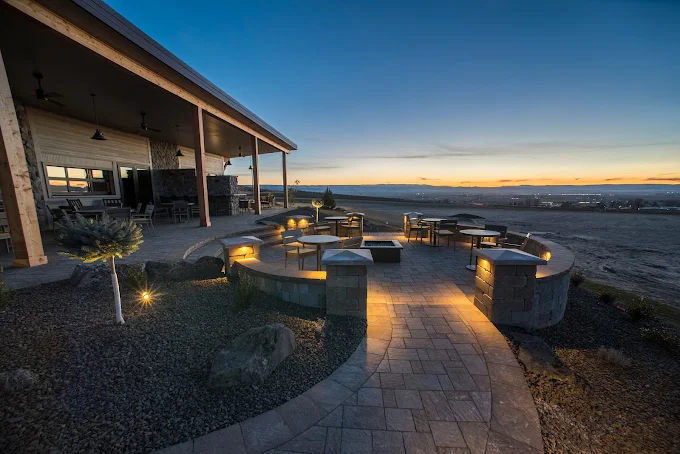 Sawtooth Winery Sunset View – Nampa, Idaho Outdoor patio at Sawtooth Winery in Nampa, Idaho at sunset, featuring fire pits, seating areas, and scenic views of the vineyard valley