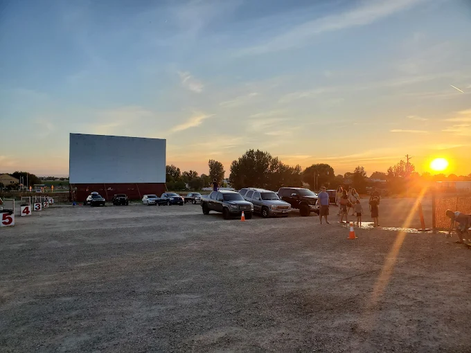 Cars parked in front of a large screen at Terrace Drive-In Theatre in Nampa, Idaho at sunset